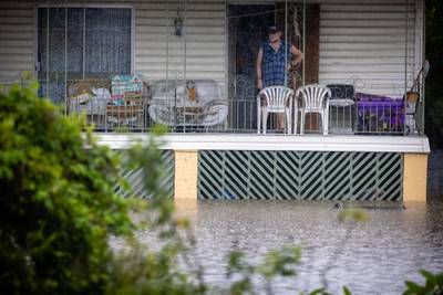 A man looks at floodwaters from the balcony of his home in West Ipswich. AFP