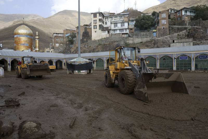 Bulldozers clear mud from the Emamzadeh Davoud shrine after flash flooding on July 28, 2022. AP Photo