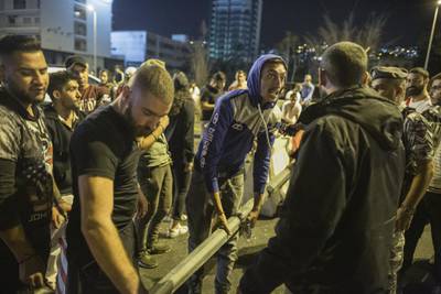 Anti-government protesters rebuild a roadblock after an hour-long amnesty in which they opened one lane to traffic on the highway entering Beirut in Jal El Dib, Lebanon. Getty Images