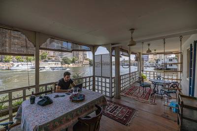 Egyptian-British citizen Omar Robert Hamilton, 37, uses a laptop as he sits on the balcony of his houseboat before its expected removal.