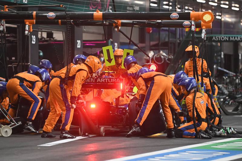 Mechanics work on the car of McLaren driver Lando Norris in the pits. AFP