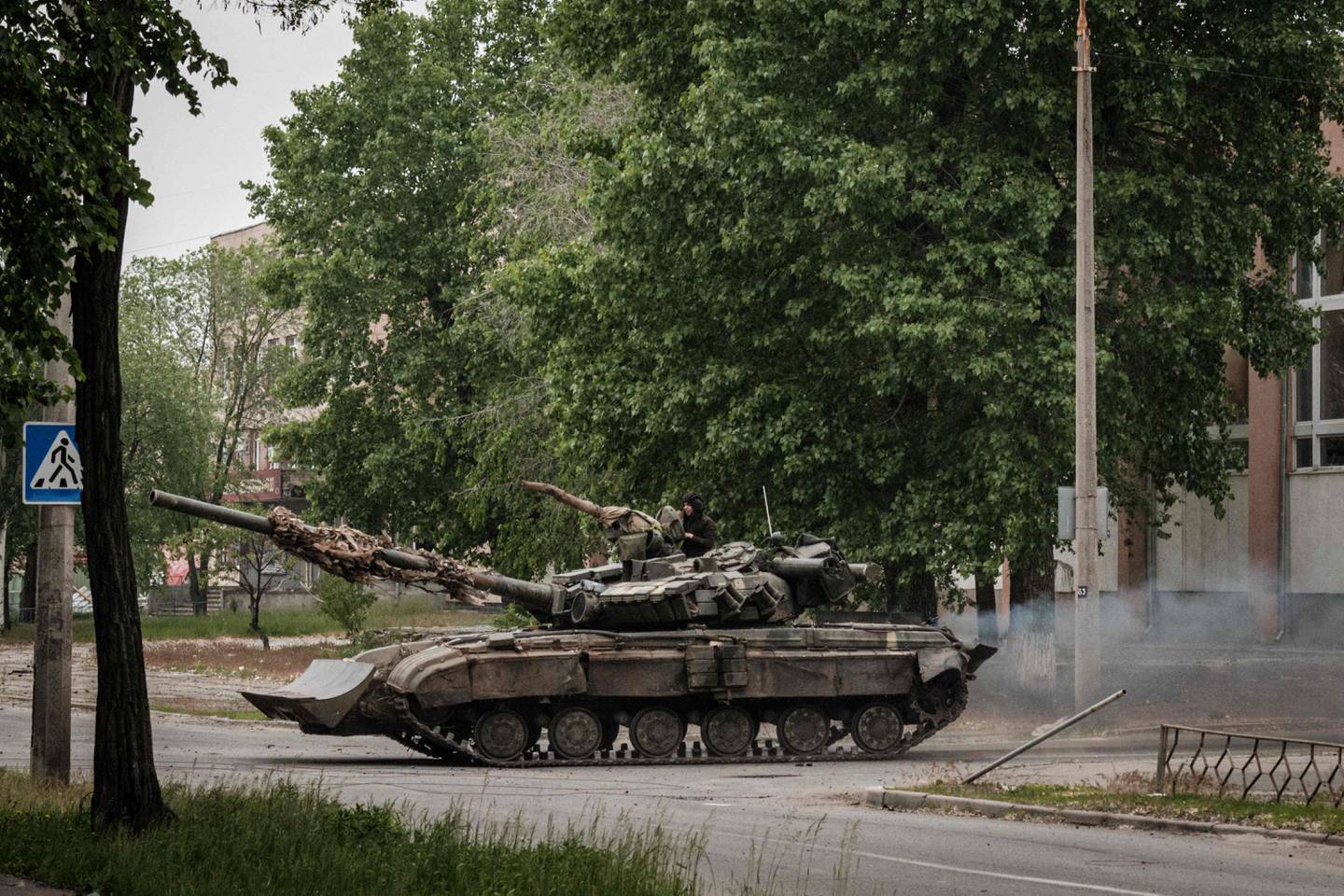 A Ukrainian main battle tank drives on a street during nearby mortar shelling in Severodonetsk, eastern Ukraine, on May 18, 2022, on the 84th day of the Russian invasion of Ukraine. AFP