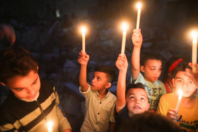 Children hold candles at the site of a house that was destroyed by Israeli air strikes during the recent Israeli-Palestinian fighting, in Gaza. Reuters