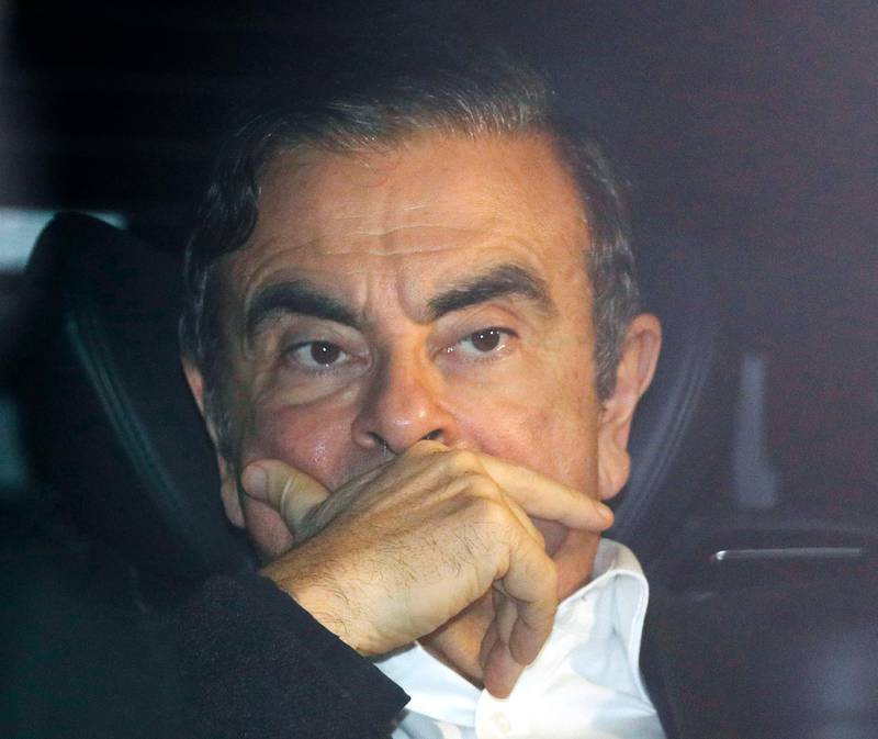Former Nissan chairman Carlos Ghosn rides in a car from a building Wednesday, March 6, 2019, in Tokyo, after posting 1 billion yen ($8.9 million) in bail once an appeal by prosecutors against his release was rejected. Ghosn, the star auto executive credited with rescuing both Renault and Nissan, left a drab Tokyo detention center Wednesday after more than three months in custody, his identity obscured by a surgical mask, hat and construction worker's outfit.(Takuya Inaba/Kyodo News via AP)