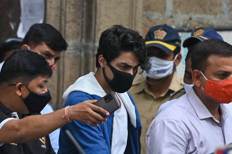 Aryan Khan is escorted to court by Narcotics Control Bureau officials for a bail plea hearing in Mumbai. AFP