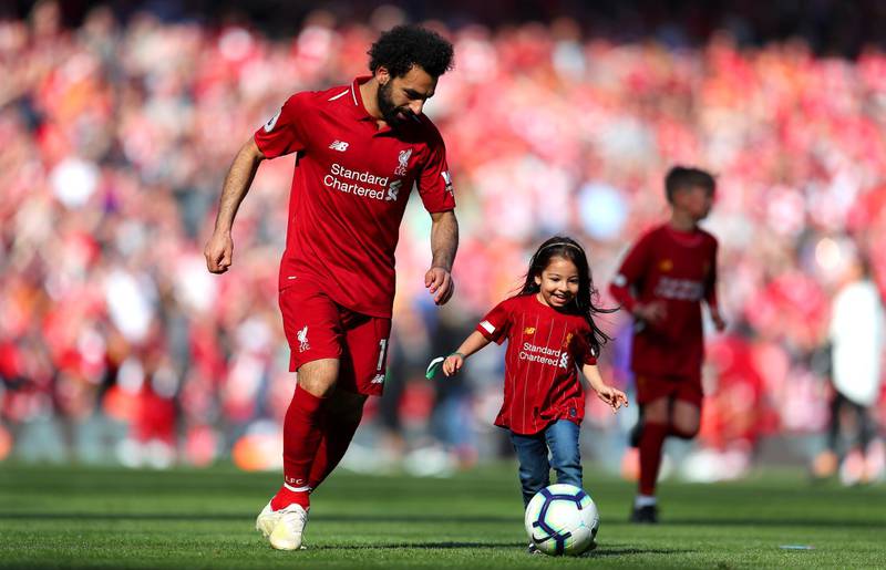 Mohamed Salah dribbles the ball with his daughter as the Premier League season ends in 2020. Getty Images