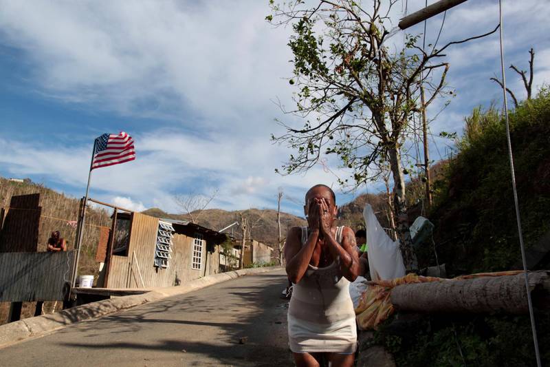 Ruth Santiago refreshes herself with water from a pipe after Hurricane Maria destroyed the town's bridge in San Lorenzo, Morovis, Puerto Rico, on October 4, 2017. Reuters