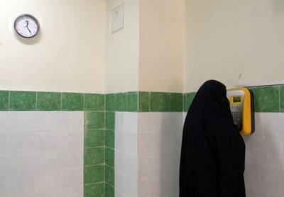 An Iranian female prisoner  makes a call  in a corridor in the Evin prison in Tehran, Iran, Tuesday, June 13, 2006. Iran boasted Tuesday that it protects human rights more than any Western country as officials led international media on a tour of the country's most feared prison in the capital Tehran. The tour of Evin prison, the first such visit by international media, came amid accusations by human rights groups that Iran has violated human rights. (AP Photo/Vahid Salemi) 