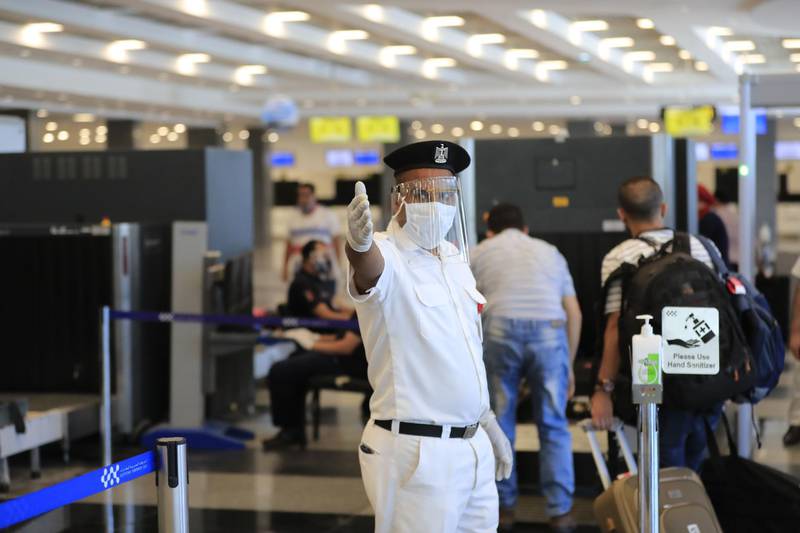 A policeman, wearing a protective face shield, signals to passengers at the Sharm el-Sheikh international airport in Egypt. AFP