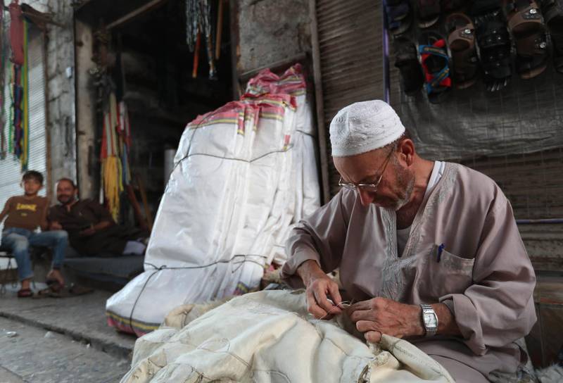 An elderly Syrian weaves a quilt in the rebel-held town of Maaret al-Numan, in the north of Idlib province on September 27, 2018.  / AFP / OMAR HAJ KADOUR
