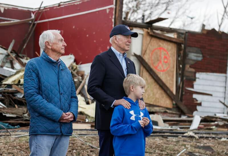 Mr Biden, centre, stands with former Kentucky governor Steve Beshear, left, and Dane Maddox as he inspects damage from a tornado that struck the state on December 10. EPA