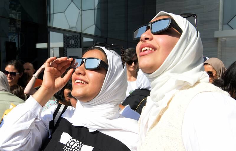 People wear protective glasses to observe the celestial event in Kuwait city. EPA