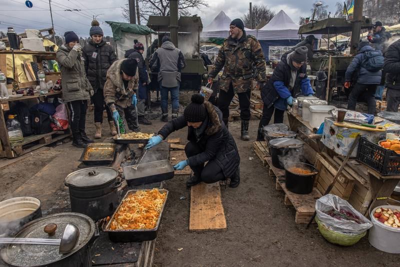Local residents cook at a makeshift camp next to a checkpoint in Kyiv. EPA