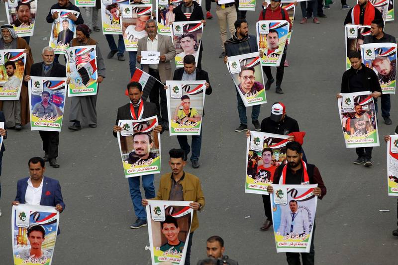 Iraqis hold pictures of killed demonstrators in the capital Baghdad's Tahrir Square, amid ongoing anti-government protests, on December 6, 2019.  Tahrir has become a melting pot of Iraqi society, occupied day and night by thousands of demonstrators angry with the political system in place since the aftermath of the US-led invasion of 2003 and Iran's role in propping it up. / AFP / AHMAD AL-RUBAYE
