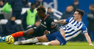 Chelsea's Tammy Abraham, left, gets tackled by Brighton & Hove Albion's Lewis Dunk. EPA
