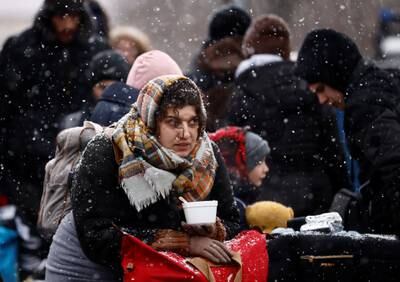 A person fleeing Ukraine sits during snowfall at a temporary camp in Przemysl, Poland. Reuters
