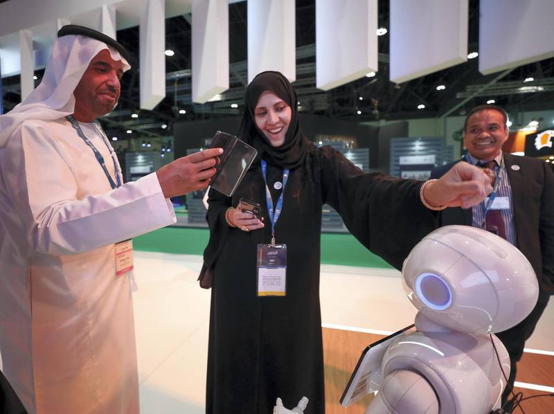 Abu Dhabi, UAE,  April 17, 2018.  CITYSCAPE Abu Dhabi 2018.  Chafika Al Baloushi gets entertained by Pepper the robot at The Department of Urban Planning and Municipalities.Victor Besa / The NationalNationalReporter:  Sarah Townsend