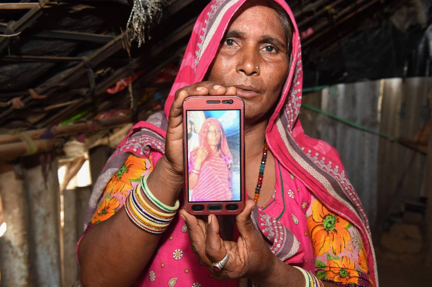 Mohinidevi Nath displays a photo on a mobile phone of her cousin Shantadevi Nath, who was killed by a mob that falsely believed she was intent on abducting children, on the outskirts of Ahmedabad in India's western Gujarat state on June 27, 2018. Indian police urged people on June 27 not to believe false rumours spread on WhatsApp after a woman was killed and a dozen hurt in the latest mob attacks to leave authorities looking powerless. / AFP / SAM PANTHAKY
