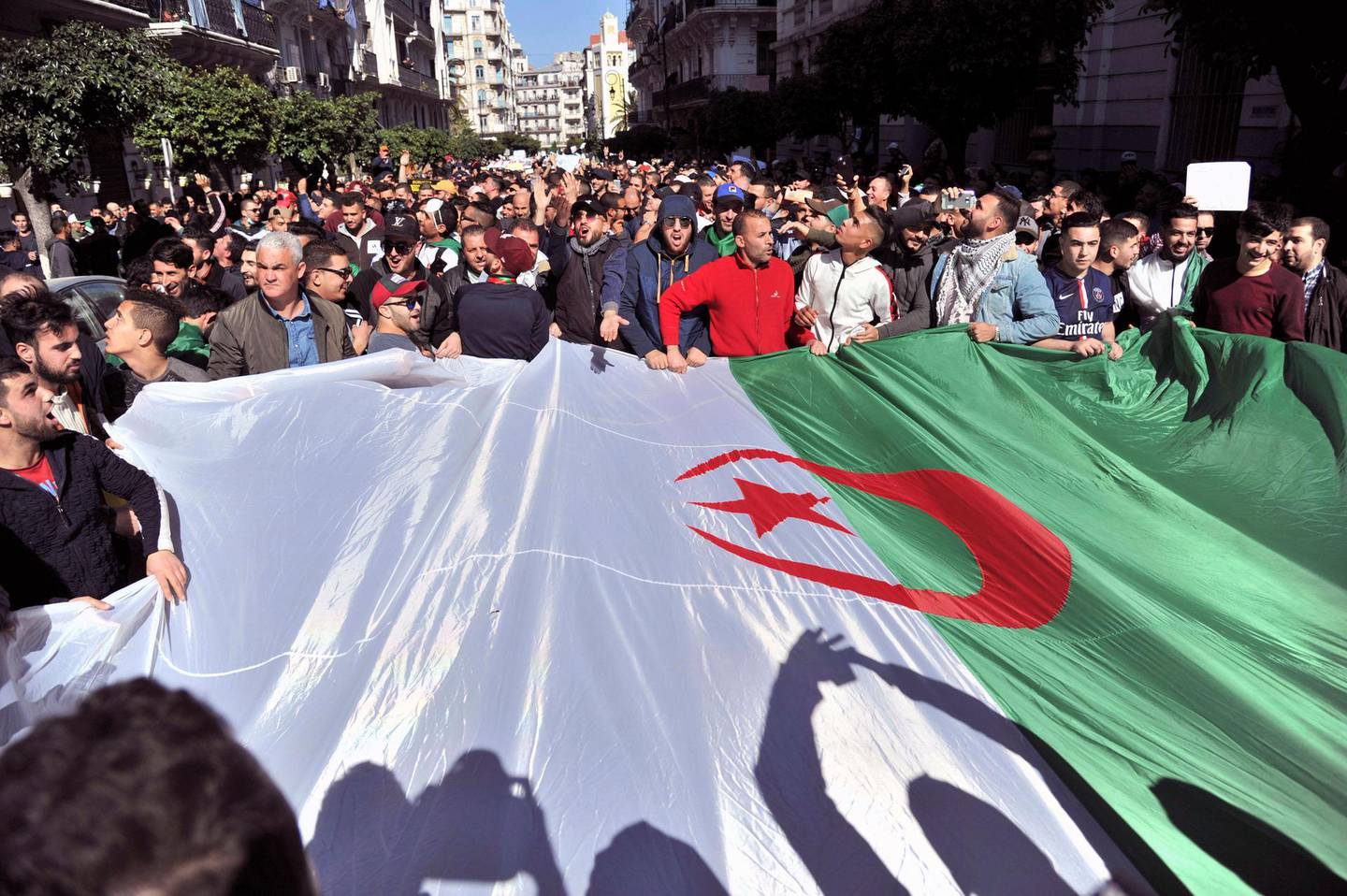 Protesters demonstrate in the streets of Algiers, Algeria, to denounce President Abdelaziz Bouteflika's bid for a fifth term, Friday, March 1, 2019. Tens of thousands of protesters marched through Algeria's capital Friday against ailing President Abdelaziz Bouteflika's bid for a fifth term, surging past a barricade and defying repeated volleys of tear gas fired by police during the tense demonstration. Banner in Arabic reads "No to the fifth mandate". (AP Photo/Slimane Zohir)