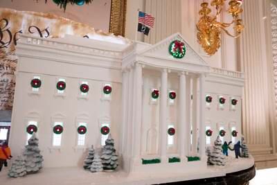 A gingerbread White House creation, including 20 sheets of sugar cookie dough, 30 sheets of gingerbread dough, 100 pounds of pastillage, 30 pounds of chocolate and 40 pounds of royal icing, decorates the State Dining Room. EPA