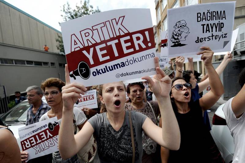 Protestors march with placards reading 'Enough! Don't turn our schools to Imam Hatips' on August 25, 2014 at Kadikoy in Istanbul. In recent months, parents have demonstrated outside  schools which have been turned into schools specialising in religious education combined with a modern curriculum. Ozan Kose/AFP Photo