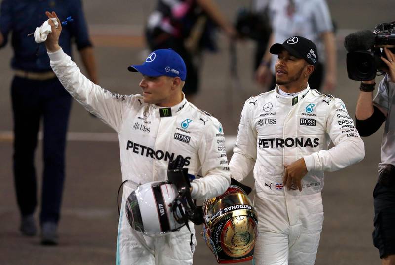 Mercedes drivers Valtteri Bottas of Finland, left, and Lewis Hamilton of Britain walk together after the qualifying for Sunday's Emirates Formula One Grand Prix at the Yas Marina racetrack in Abu Dhabi, United Arab Emirates, Saturday, Nov. 25, 2017. Bottas clocked the fastest time and Hamilton was second. (AP Photo/Hassan Ammar)