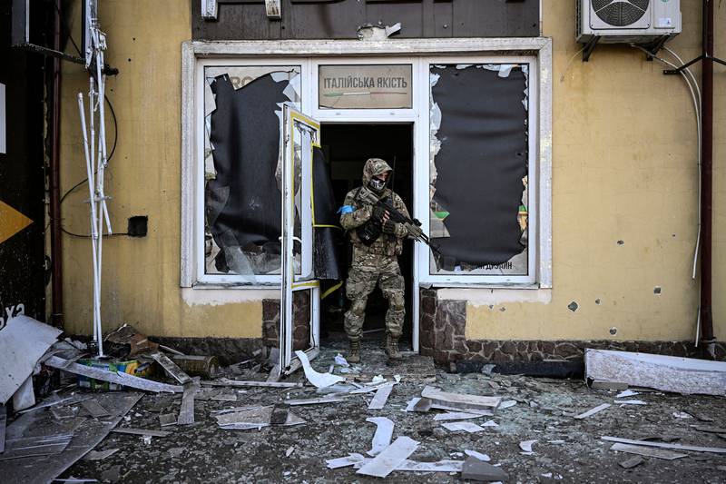 A Ukrainian soldier leaves a damaged building after shelling in Kyiv. AFP