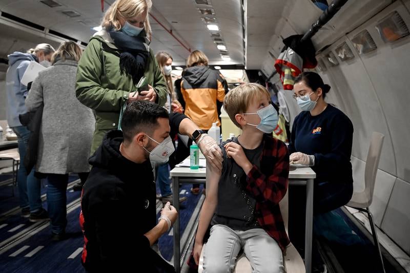 Jannik, 9, gets vaccinated in an airplane at Cologne Bonn Airport in Germany.  The city is hosting a special vaccination event for children aged 5 to 11 in a decommissioned Airbus A300 Zero G. EPA