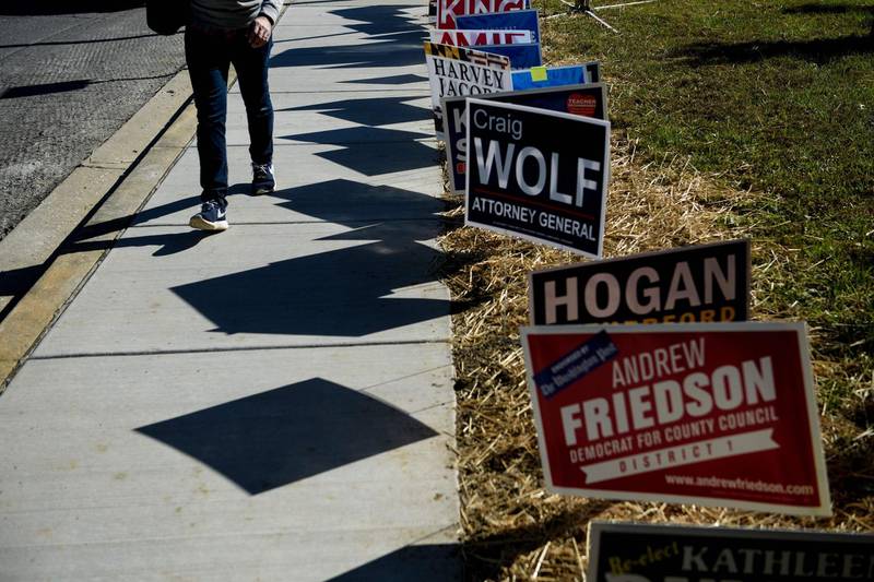 A man walks away past campaign signs after voting during early voting at a community center in Potomac, Maryland, two weeks ahead of the key US midterm polls. AFP