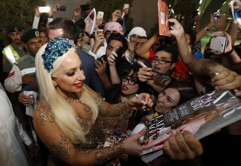 Lady Gaga signs her autograph for fans as she arrives at Dubai International airport. Karim Sahib / AFP photo