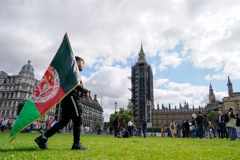 A demonstrator holds an Afghanistan flag during a protest at Parliament Square in London. AP