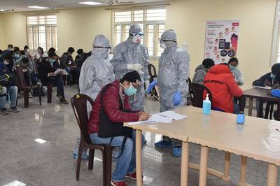 epa08251853 A handout photo made available by the Indo-Tibetan Border Police (ITBP) shows officials wearing protective suits stand in a room with evacuees, who have been taken out of the Chinese city of Wuhan, inside the Chhawla Quarantine Facility in New Delhi, India, 27 February 2020. A group of 76 Indians and 36 foreign nationals, including eight families with children, have been evacuated by the Indian government from Wuhan, the epicenter of the novel coronavirus outbreak, and kept in the Chhawala quarantine facility. According to authorities, so far none of the evacuees has been tested positive to the Covid-19 disease.  EPA/INDO-TIBETAN BORDER POLICE HANDOUT -- BEST QUALITY AVAILABLE -- HANDOUT EDITORIAL USE ONLY/NO SALES/NO ARCHIVES