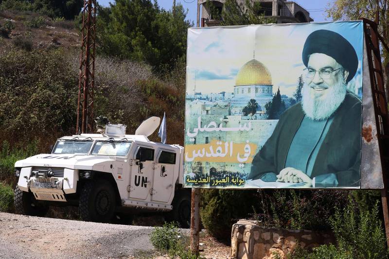 An armoured Unifil vehicle patrols near a billboard with a portrait of Hassan Nasrallah, the head of Lebanon's powerful Shiite armed group Hezbollah, in the southern town of Houla. AFP