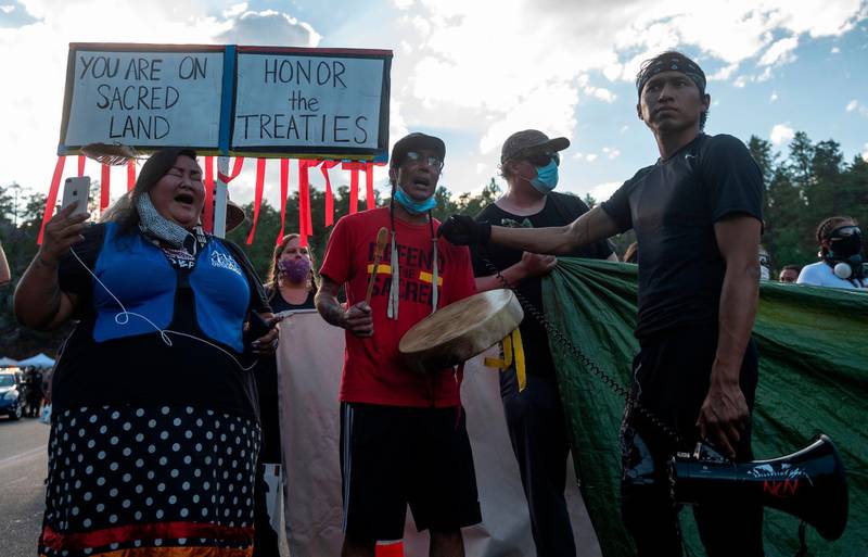 Activists and members of different tribes from the region block the road to Mount Rushmore National Monument as they protest in Keystone, South Dakota on July 3 during a demonstration around the Mount Rushmore National Monument and the visit of US President Donald Trump.  Andrew Caballero-Reynolds/ AFP