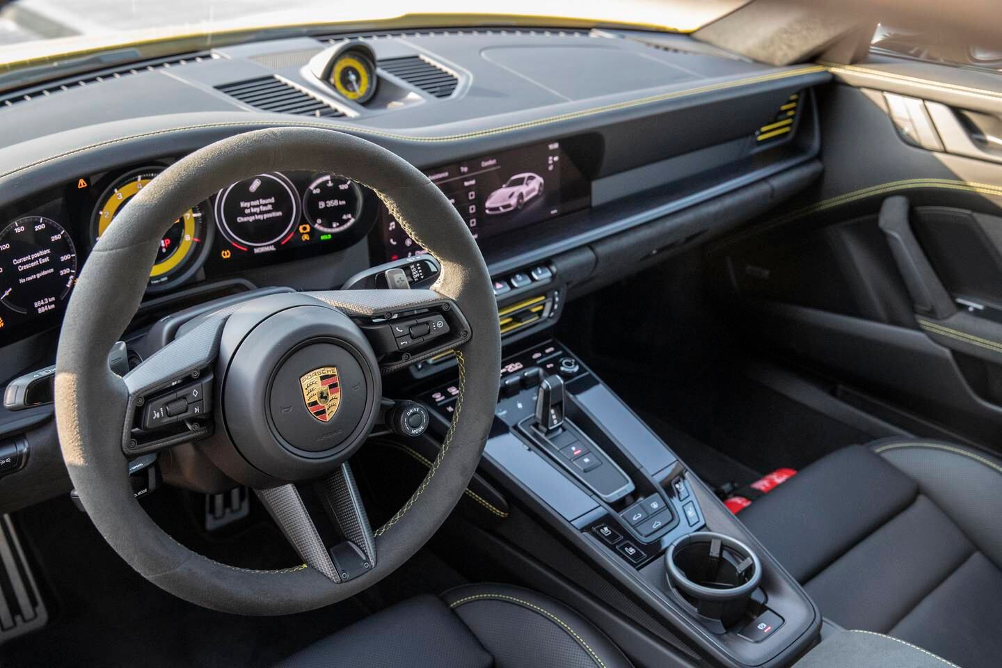 The three-spoke steering wheel and yellow tachometer in the new Porsche 911 Carrera GTS. Antonie Robertson / The National 


