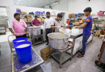 DUBAI,  UNITED ARAB EMIRATES, 20 May 2018 - Staff starts to place the porridge in a small containers to serve during iftar at Wonder  Chef Catering, Al Quoz, Dubai. Leslie Pableo for The National  for Ramola Talwar story