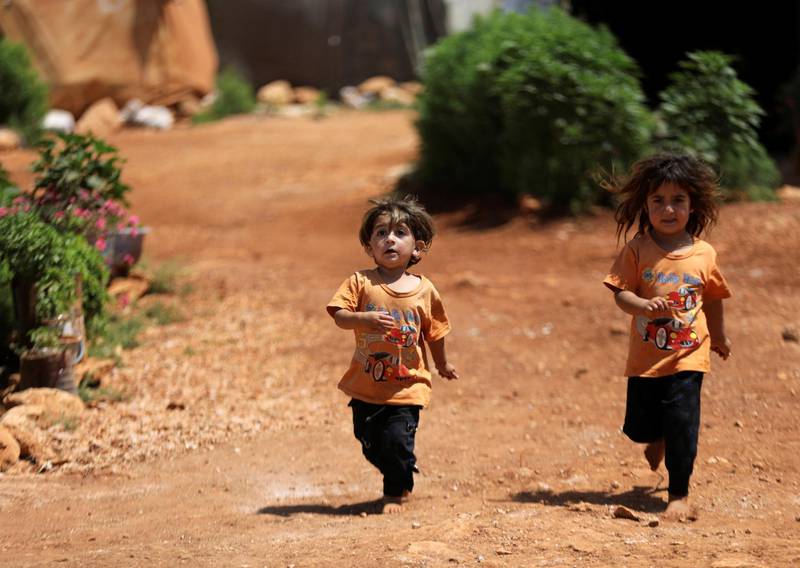 Children run near tents at a camp for internally displaced people in northern Idlib, Syria. Reuters