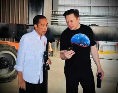 Mr Musk shows Mr Widodo his mobile phone during a tour of the SpaceX launch site in Texas. Reuters