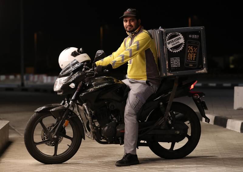 Delivery rider Malik Shahzad receives an iftar box at Aloft Dubai South. Chris Whiteoak / The National