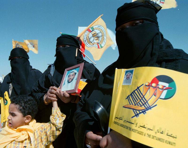 Kuwaiti sisters (L-R) Wafa, Latifa and Wadjid hold a photograph of their brother Abu Jarrah, February 25 one of some 600 prisoners of war taken by Iraq since they invaded their tiny Gulf neighbor in 1990. Kuwaitis, holding yellow flags and posters of loved ones, gathered at one of the most remembered sites where retreating Iraqi troops were killed by allied forces in a bombing raid on the last day before liberation of the country from Iraqi occupiers eight years ago tomorrow.Reuters