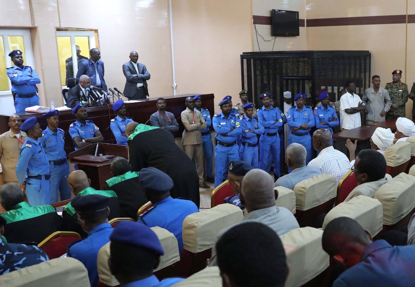 epa08070522 Presiding judge Al-Sadiq Abdelrahman (top L) reads the verdict against Sudan's ousted president Omar Hassan al-Bashir in the defendant's cage (top C) during his trial in Khartoum, Sudan, 14 December 2019. A Sudanese court in Khartoum on 14 December 2019 found former president al-Bashir guilty of money laundering and sentenced him to two years in rehabilitation facility. The verdict is the first in several cases against al-Bashir who was ousted in April 2019 after some 30 years in power.  EPA/MORWAN ALI