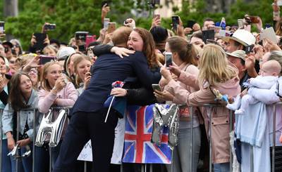 Britain's Prince Harry embraces India Brown during a public walk in Melbourne on October 18, 2018. Thousands of royal fans in Melbourne waited in the rain on October 18 to get a glimpse of Prince Harry and his pregnant wife Meghan, with some overwhelmed by the experience.  / AFP / POOL / WILLIAM WEST
