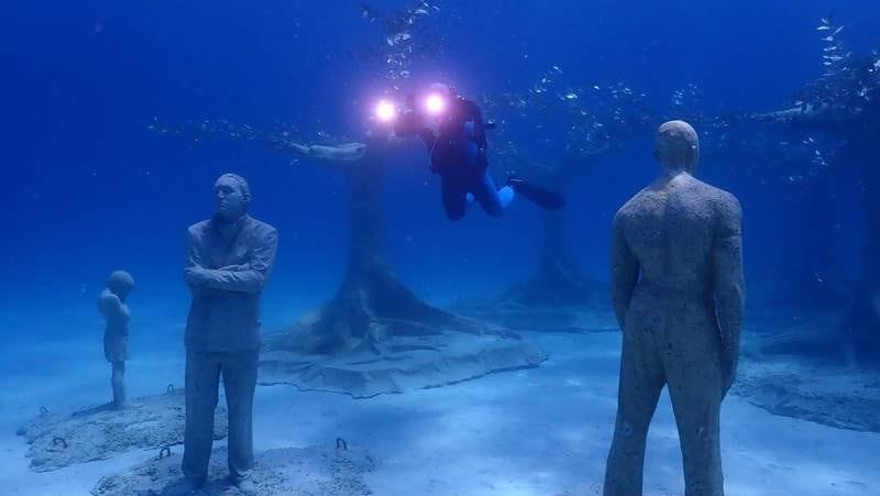A diver swims near sculptures during the inauguration of the underwater museum in Ayia Napa, Cyprus.