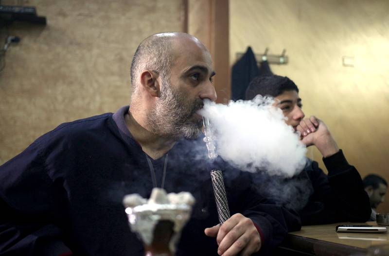 Jordanians smoke shisha late into the night at a coffee shop in Amman. Mohammed Hannon / AP Photo