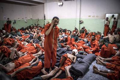 Men, suspected of being affiliated with the Islamic State (IS) group, gather in a prison cell in the northeastern Syrian city of Hasakeh on October 26, 2019. - Kurdish sources say around 12,000 IS fighters including Syrians, Iraqis as well as foreigners from 54 countries are being held in Kurdish-run prisons in northern Syria. (Photo by FADEL SENNA / AFP)