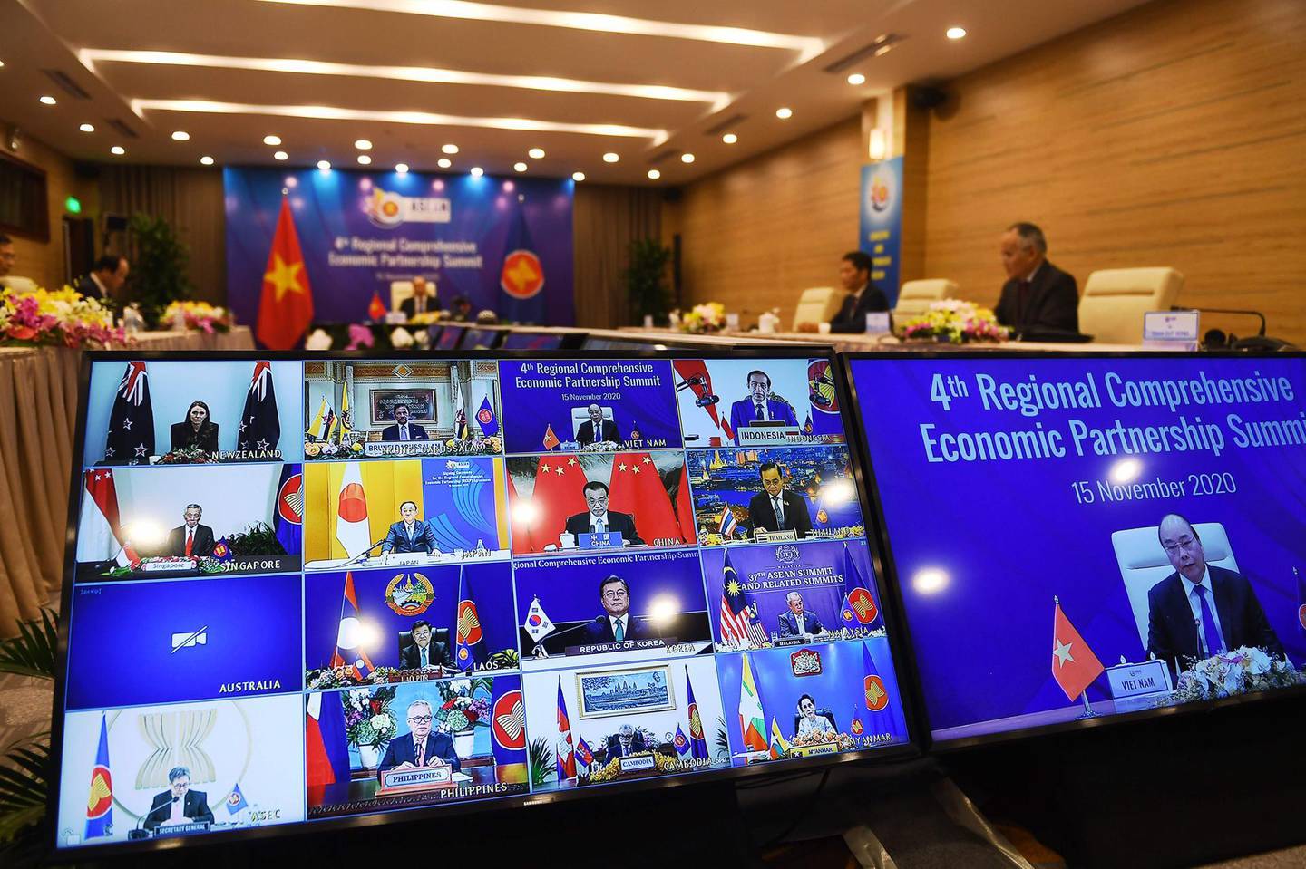 Vietnam's Prime Minister Nguyen Xuan Phuc is pictured on the screen (R) as he addresses his counterparts during the 4th Regional Comprehensive Economic Partnership (RCEP) Summit at the Association of Southeast Asian Nations (ASEAN) summit being held online in Hanoi on November 15, 2020. / AFP / Nhac NGUYEN
