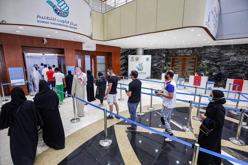 People queue as they wait their turn to receive a dose of COVID-19 coronavirus vaccine at the make-shift vaccination centre at the Kuwait International Fairground in the Mishref suburb south of Kuwait City. AFP
