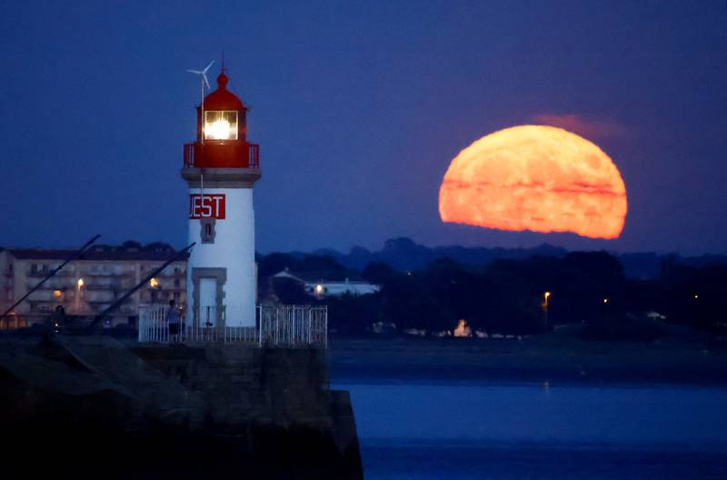 The supermoon appears behind a lighthouse in Saint-Nazaire, France.  Reuters