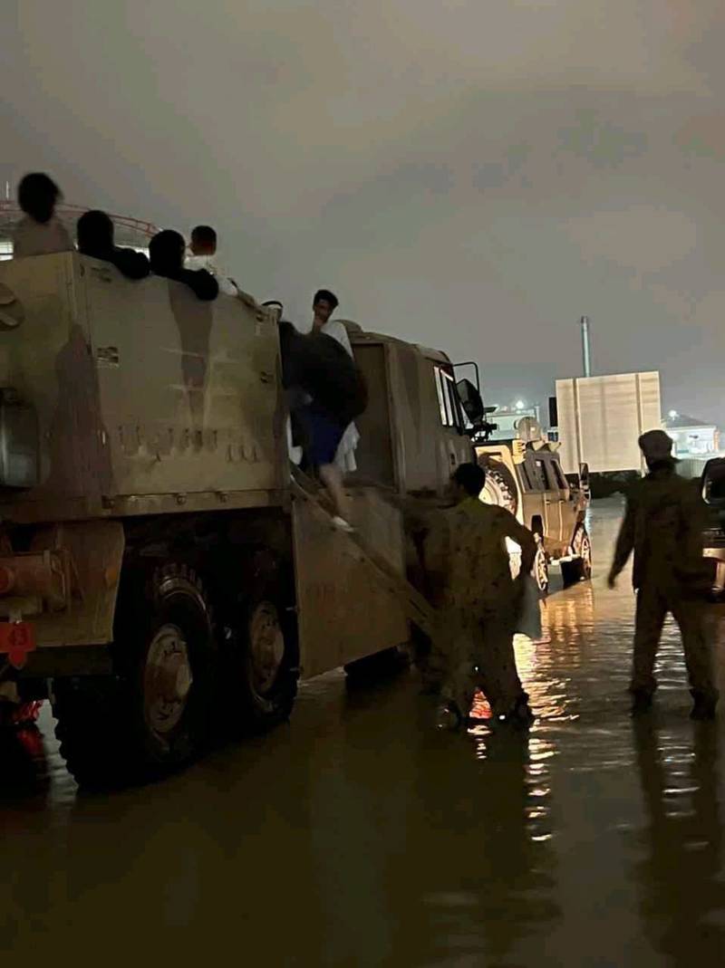 Servicemen transport families from their flood-affected homes to safety.