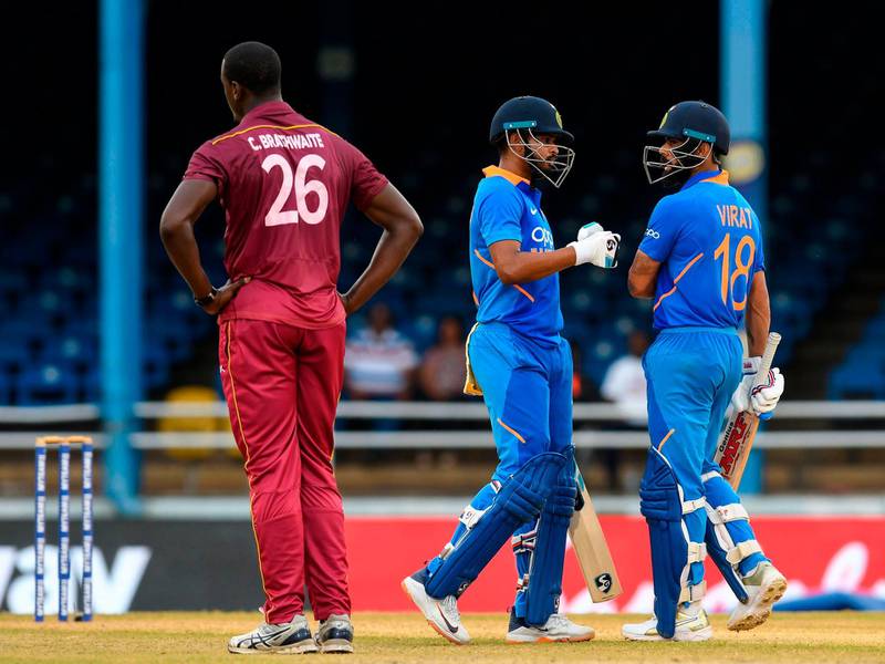 Shreyas Iyer (C) and Virat Kohli (R) of India celebrate 50 partnership as Carlos Brathwaite (L) of West Indies expresses disappointment during the 3rd ODI match between West Indies and India at Queens Park Oval, Port of Spain, Trinidad and Tobago, on August 14, 2019.  / AFP / Randy Brooks
